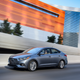 Gray sedan driving on an urban highway.